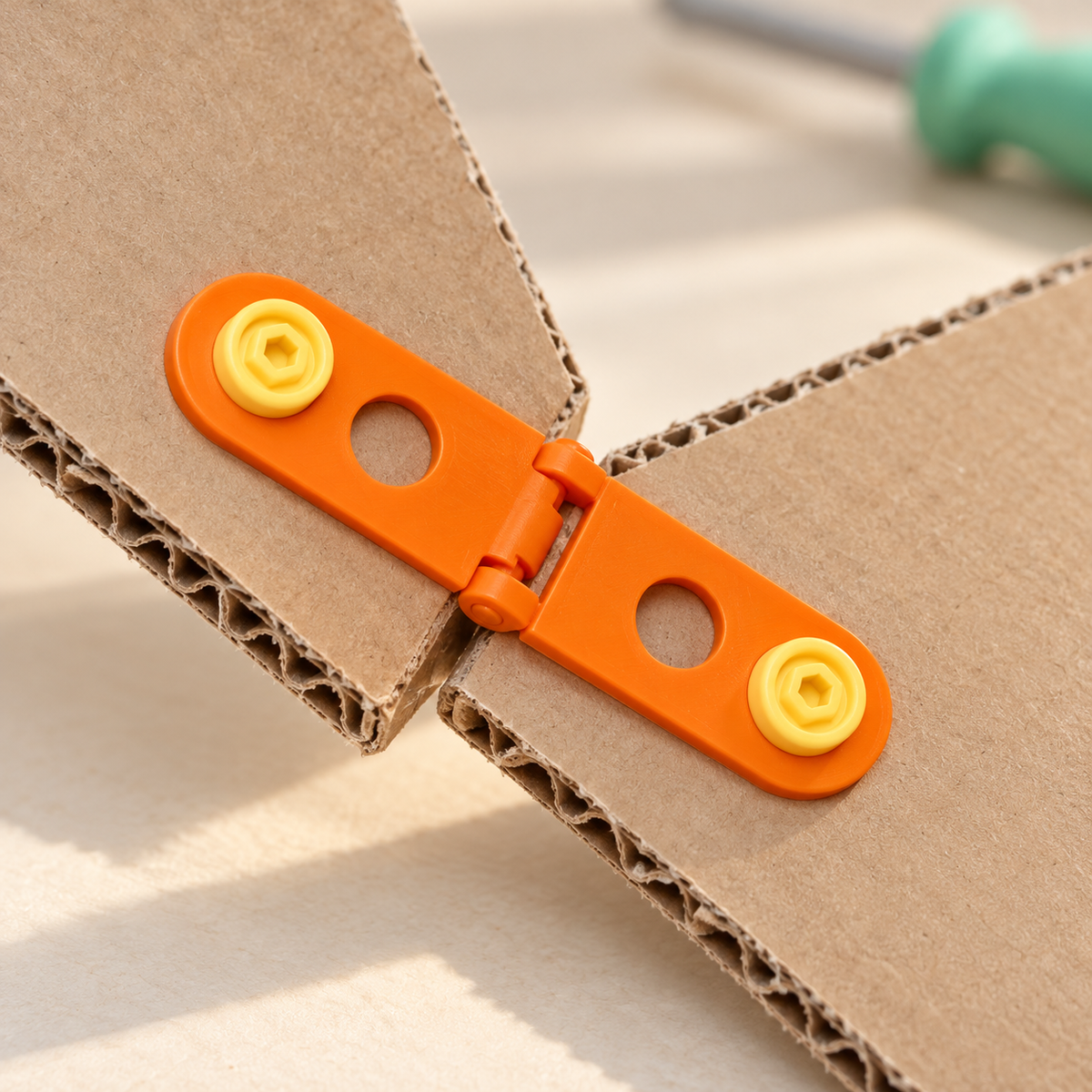 Orange hinge and yellow connectors joining cardboard